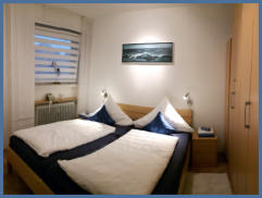 Im Schlafzimmer steht ein Doppelbett mit verstellbarem Lattenrost (1,80m x 2,00m). Zwei Nachtkonsolen, ein großer Kleiderschrank sowie ein weiterer Flachbildfernseher, sind ebenfalls vorhanden.